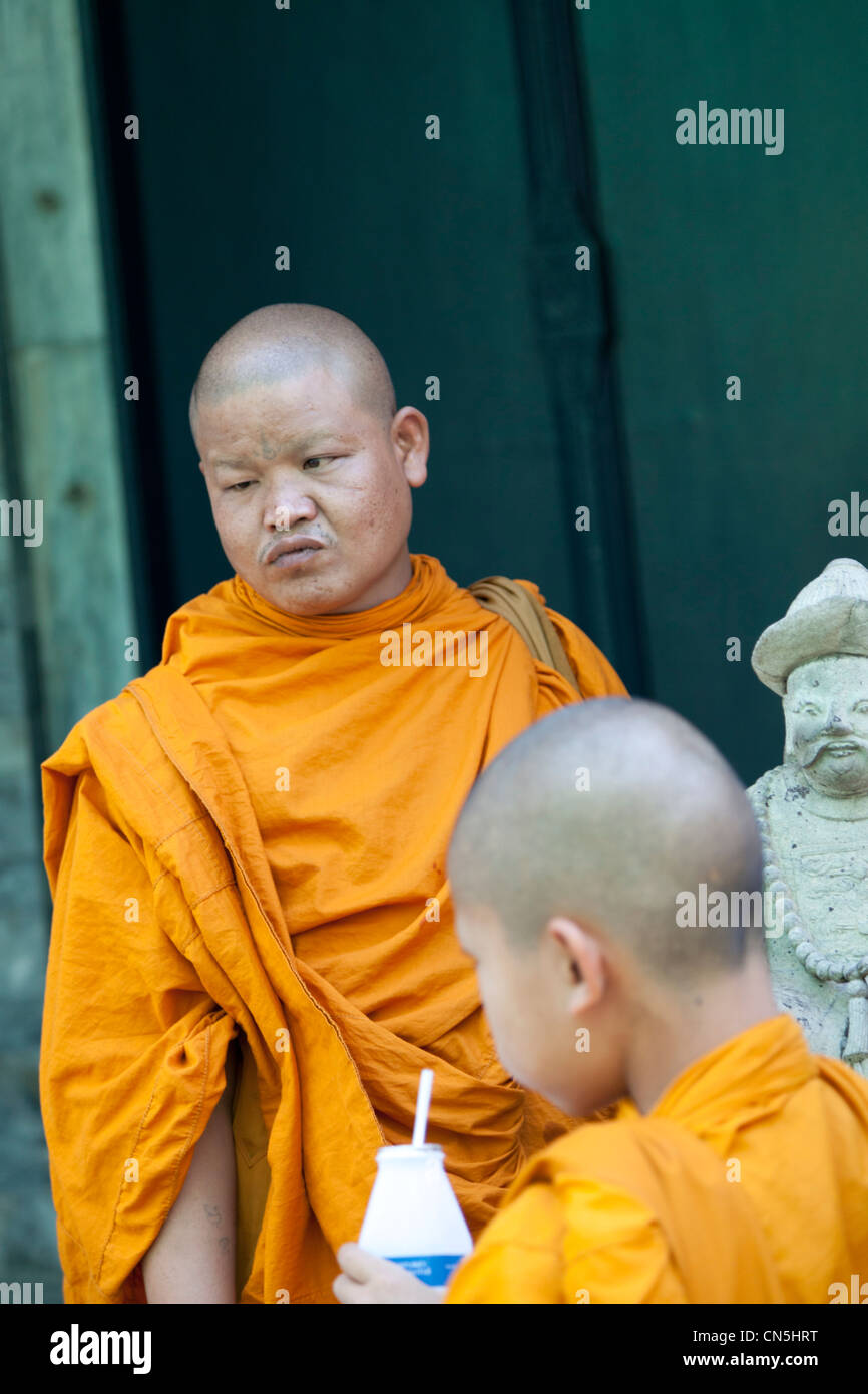 Buddhist monk and novice visiting the Phra Kaew Temple, in Bangkok (Thailand). Moine et novice visitant le temple Phra Kaew. Stock Photo