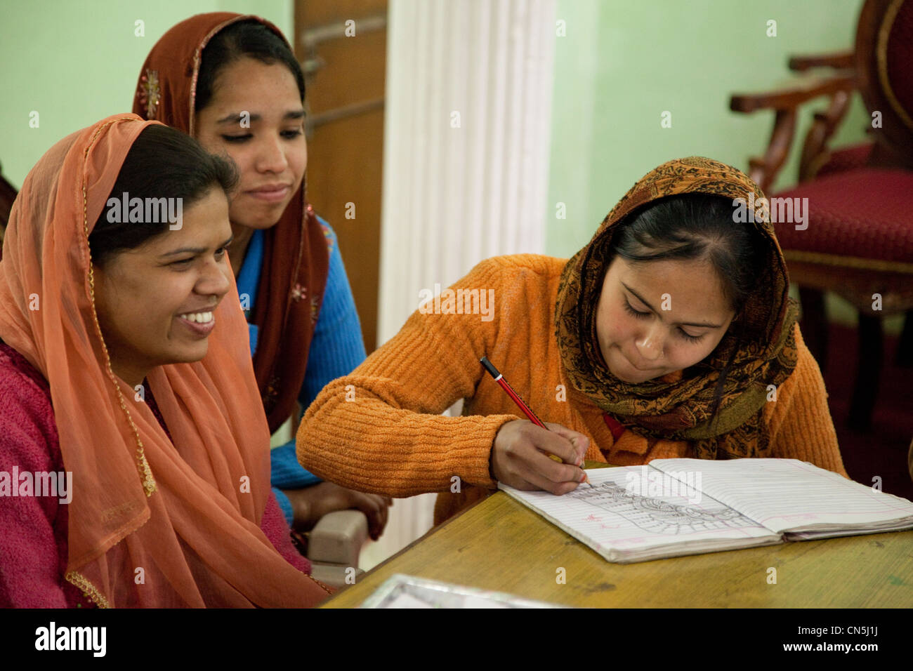 Dehradun, India. Young Muslim Indian Woman Drawing a Henna Design in her Notebook. Stock Photo