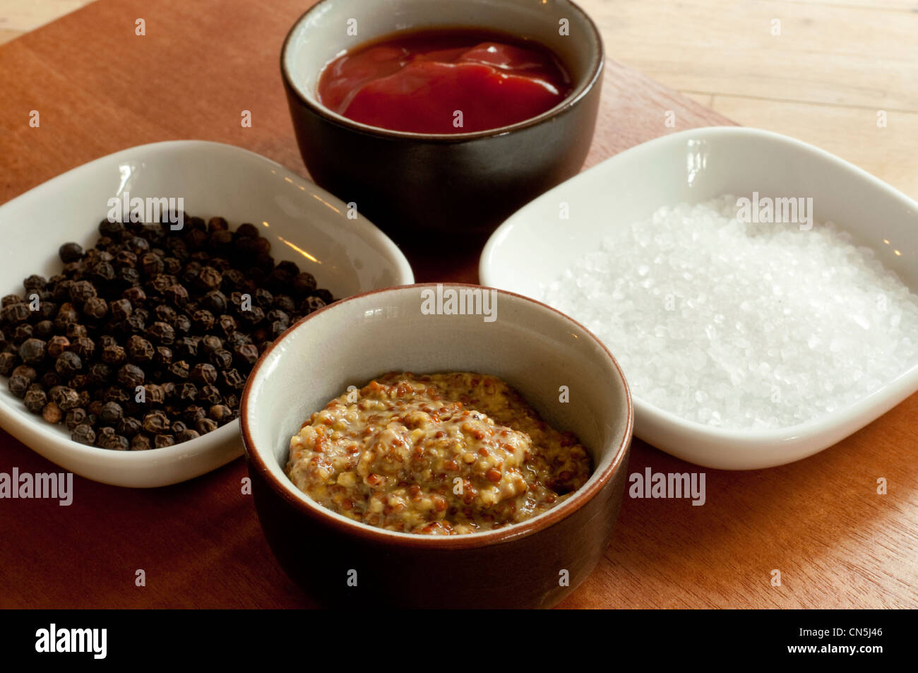 A tray of condiments salt, pepper, mustard and ketchup Stock Photo