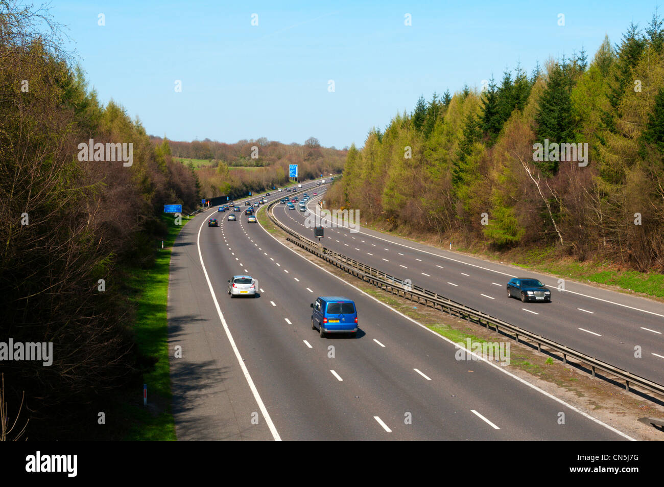 The M25 motorway in a cutting through woodland to the south east of London. View northbound parallel to Darent Valley in Kent. Stock Photo