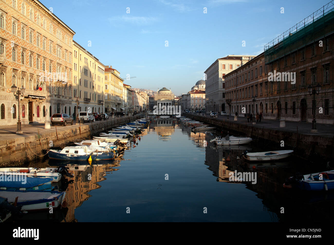 Buildings and boats reflected in the still water of the Grand Canal, Trieste, Italy Stock Photo