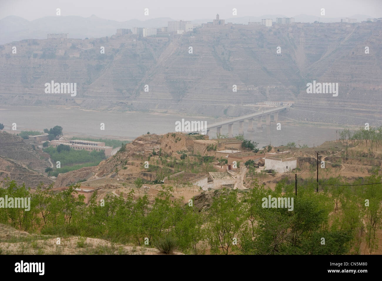 LINXIAN, HENAN PROVINCE, CHINA - JUNE 2006: Pollution obscures the view across the river. Stock Photo