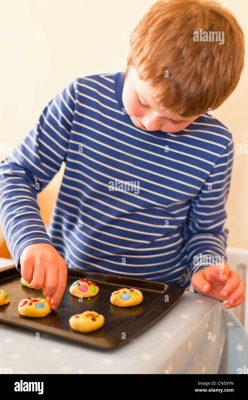 An 8 year old boy making cookies at home in England , Britain , Uk Stock Photo