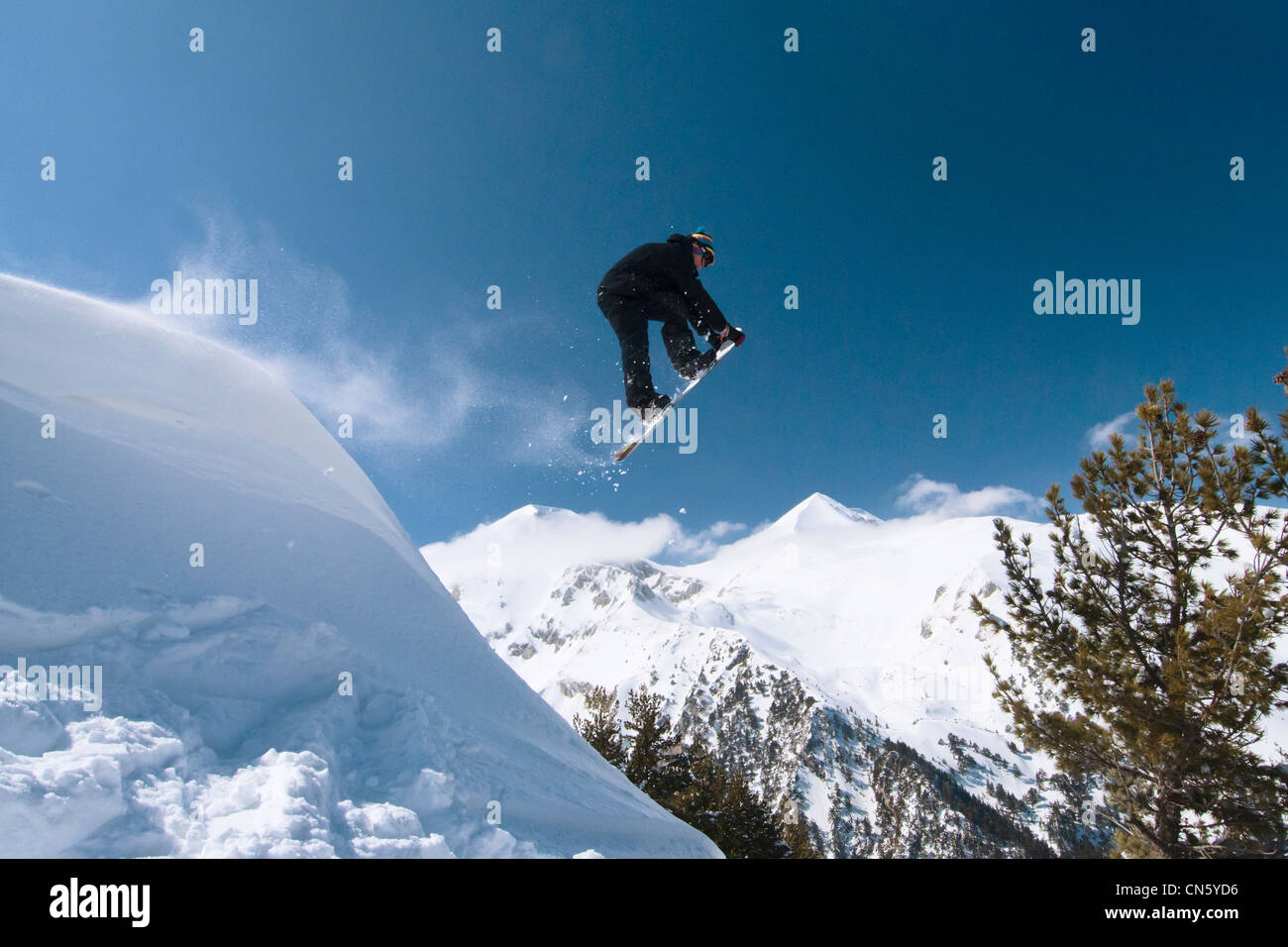 A snowboarder at jump in the back country in sunny day in Bansko Bulgaria. Stock Photo