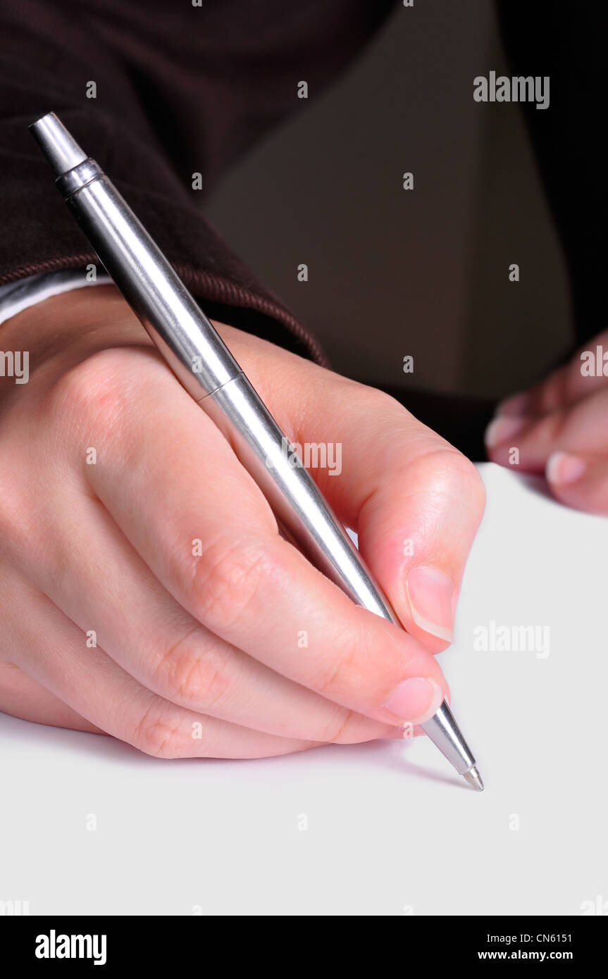 A hand, holding a pen, is ready to write on a document Stock Photo Alamy