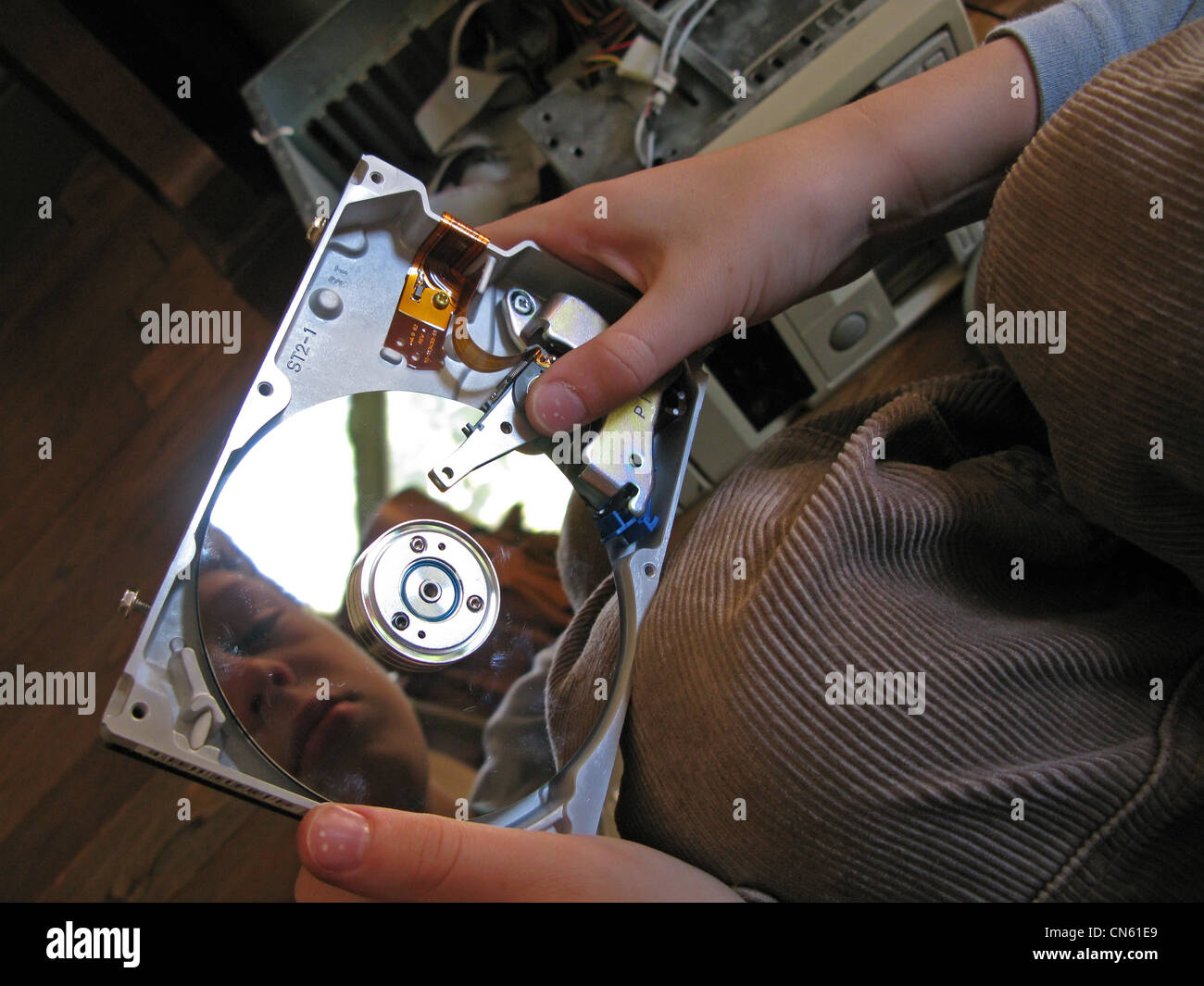 Boy looking at an opened hard drive from a computer Stock Photo