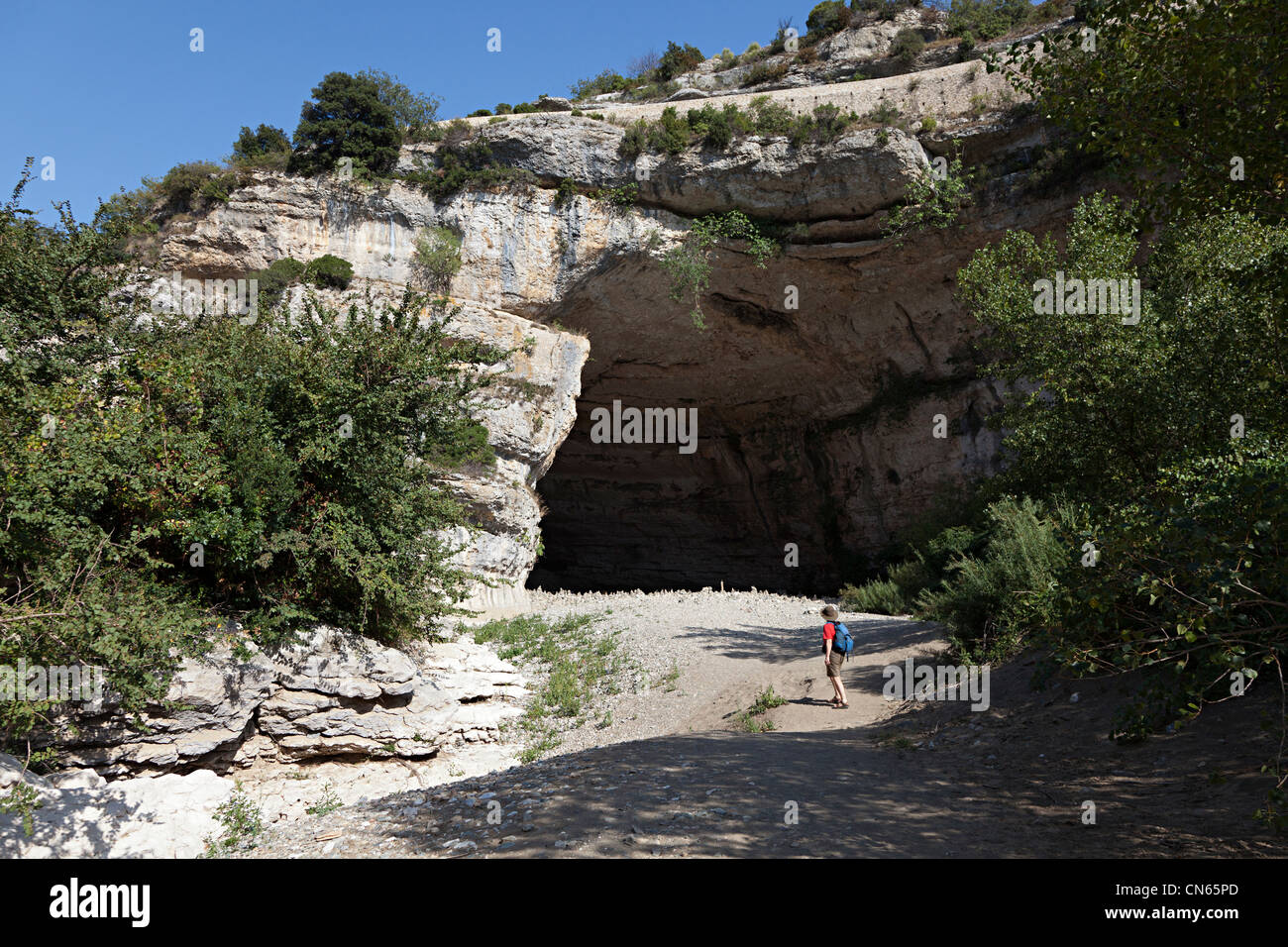 Person at the entrance to the cave below Minerve, Llanguedoc, Herault, France Stock Photo