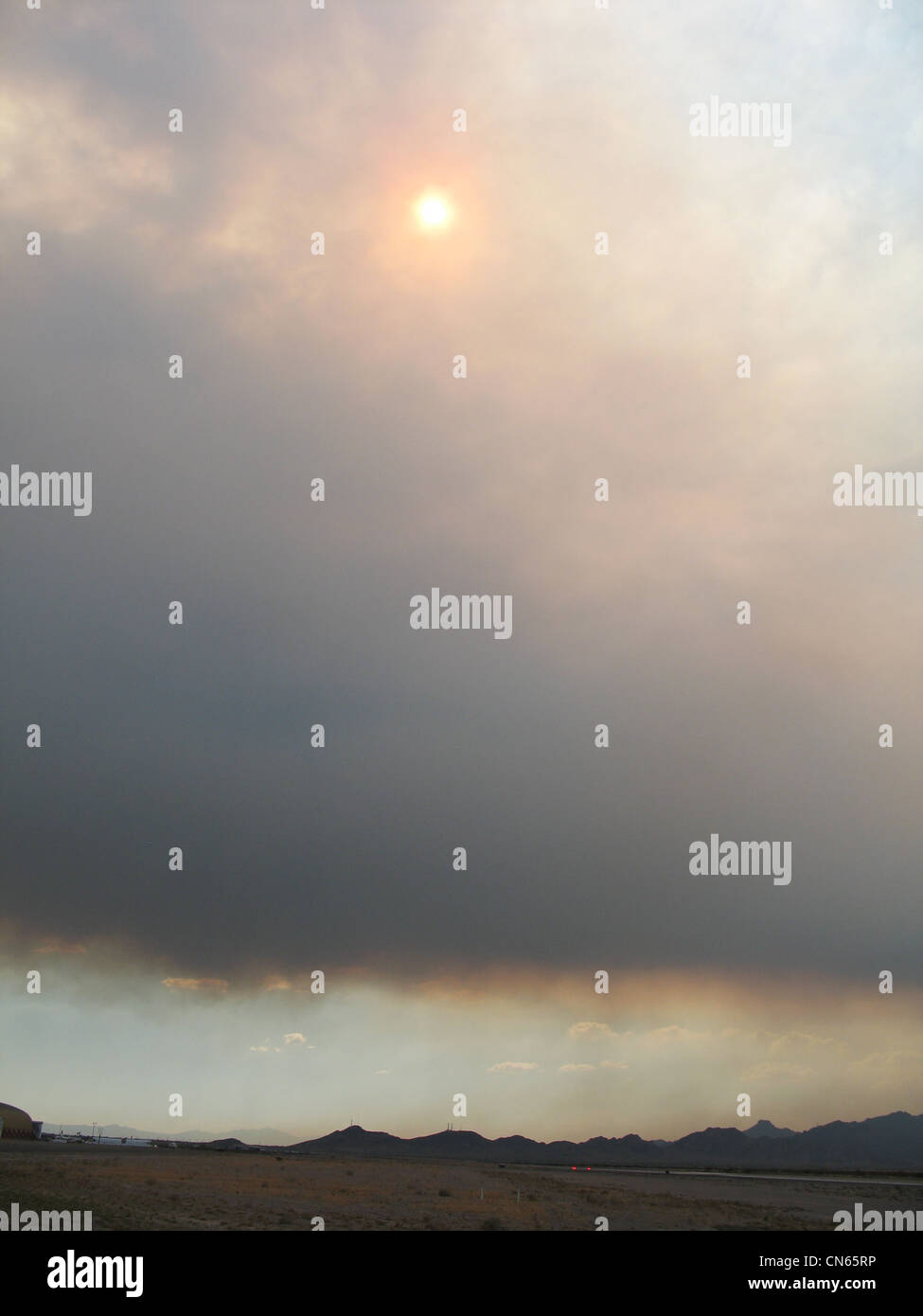 Sun penetrating thick plume of smoke Blythe fire, California Stock Photo