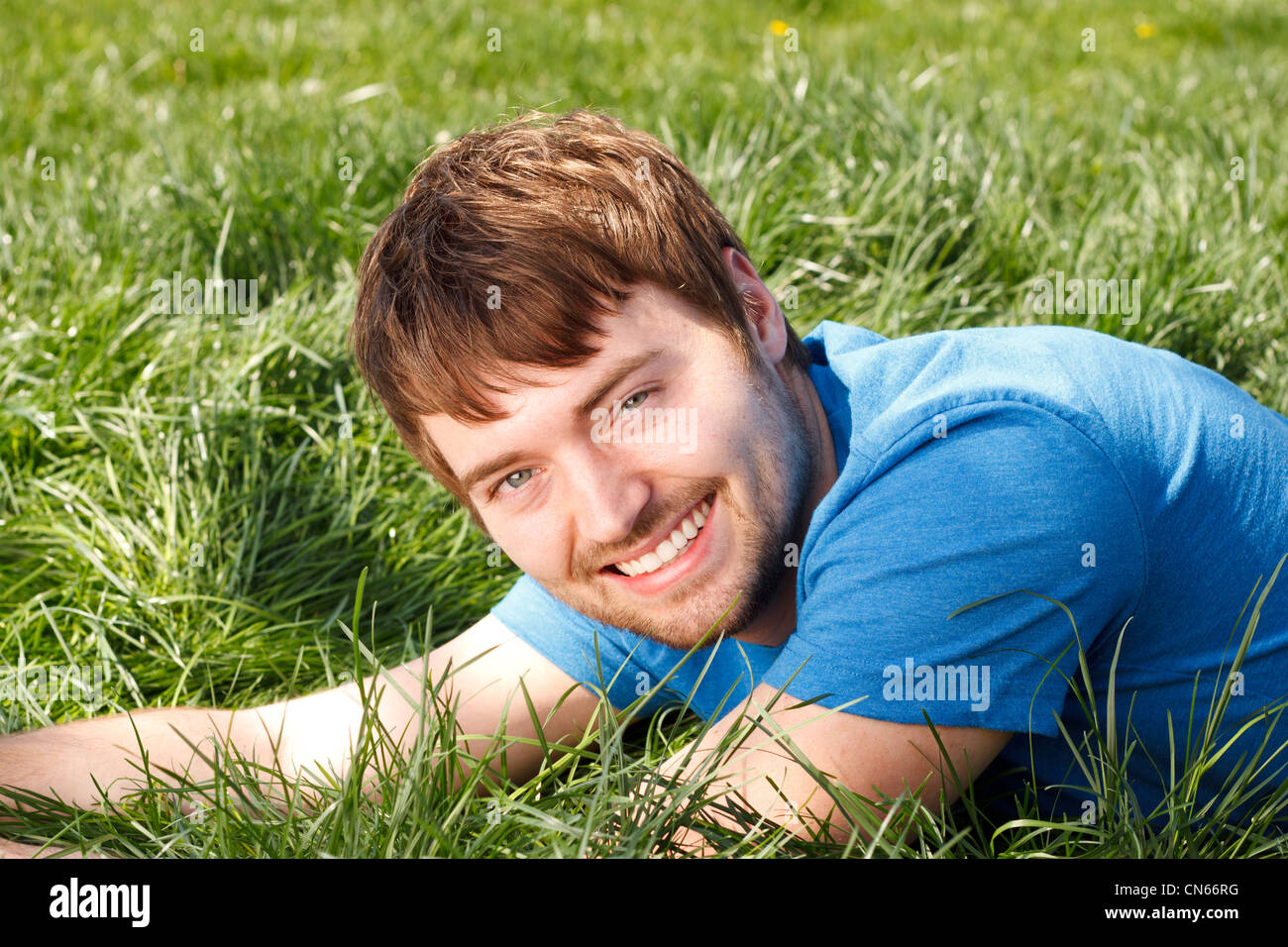 Attractive Young Man Laying In Grass Stock Photo
