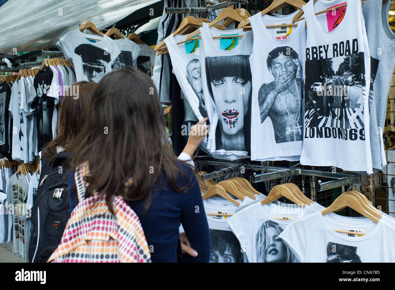 People, Shoppers buying, looking at t-shirts, vest on stall in Camden Market, Camden Town, London, England Stock Photo