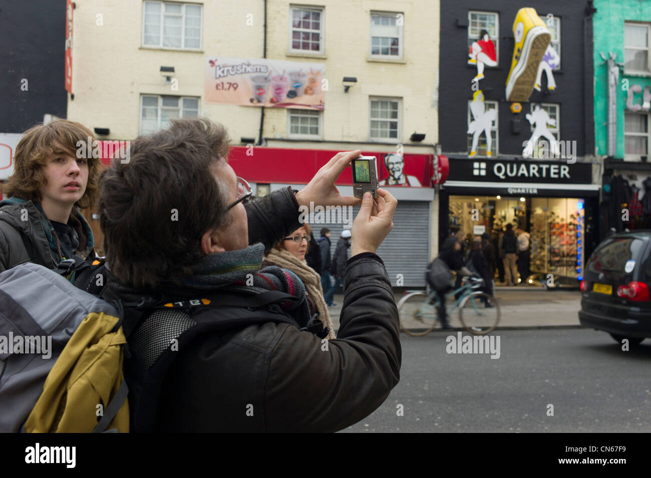 Tourist taking photographs in Camden Market, Camden Town, London, England Stock Photo