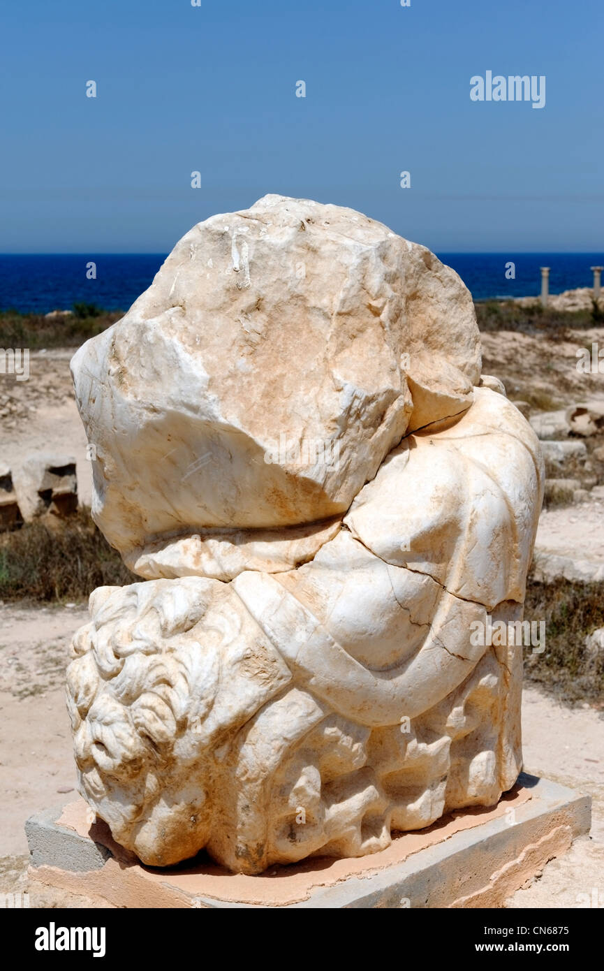 Sabratha. Libya. View at the site of the Temple of Hercules of the battered fragment of marble statue of Hercules wearing the Stock Photo