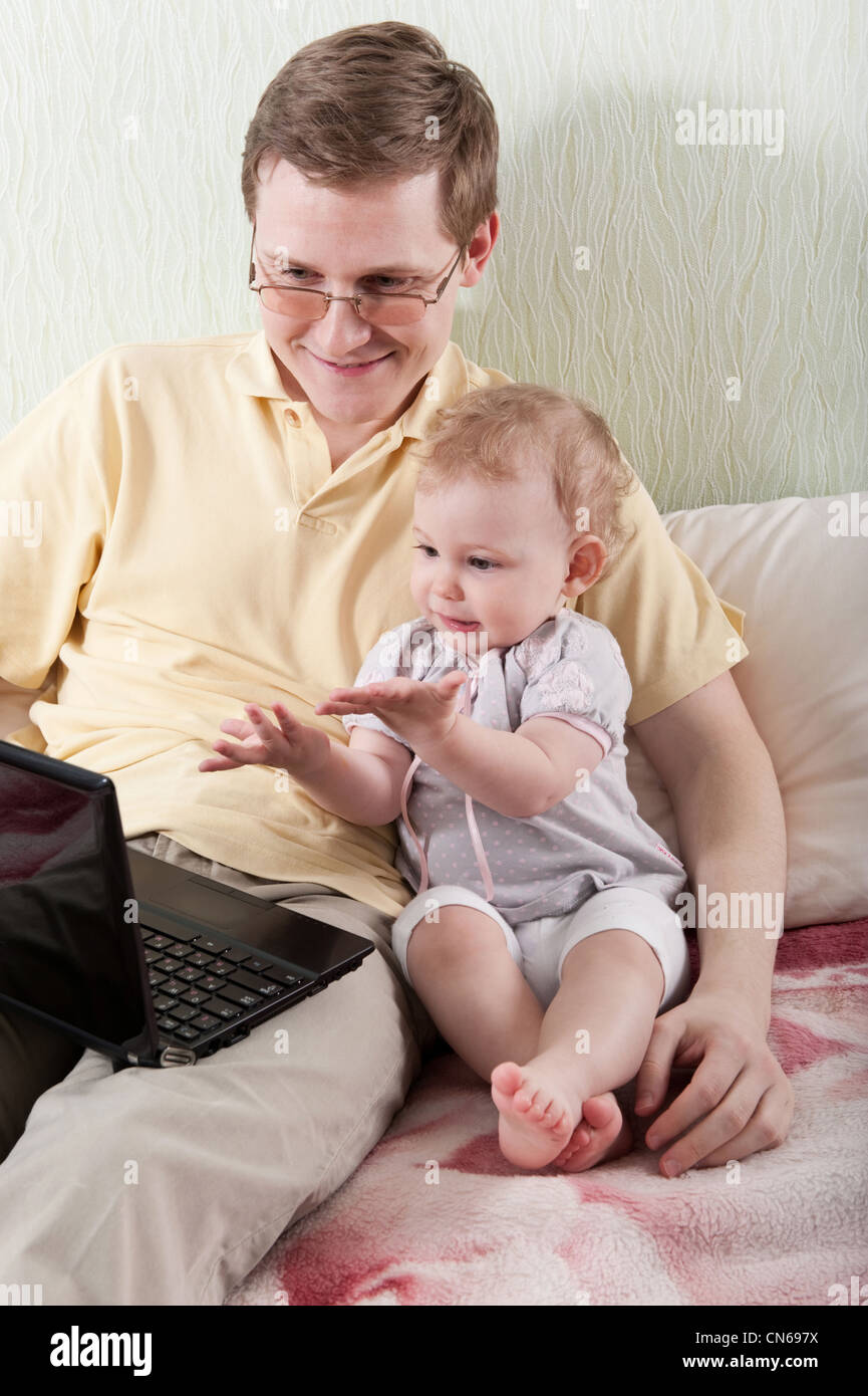 Young father with her little baby daughter with laptop Stock Photo - Alamy