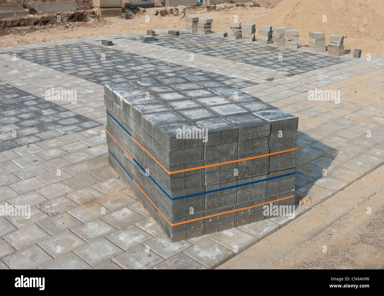 piled up bricks on a newly paved parking area Stock Photo