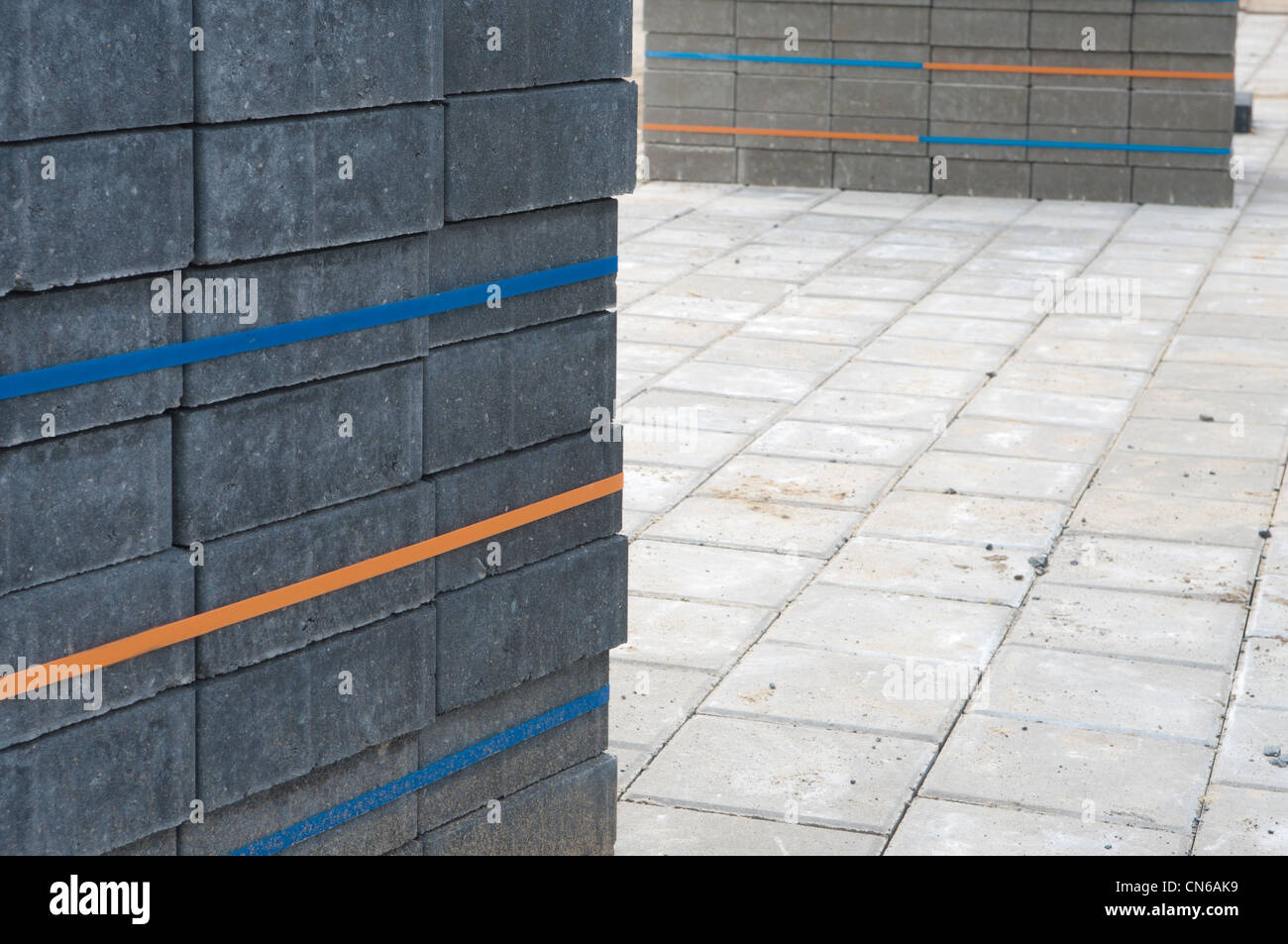 piled up bricks on a newly paved parking area Stock Photo