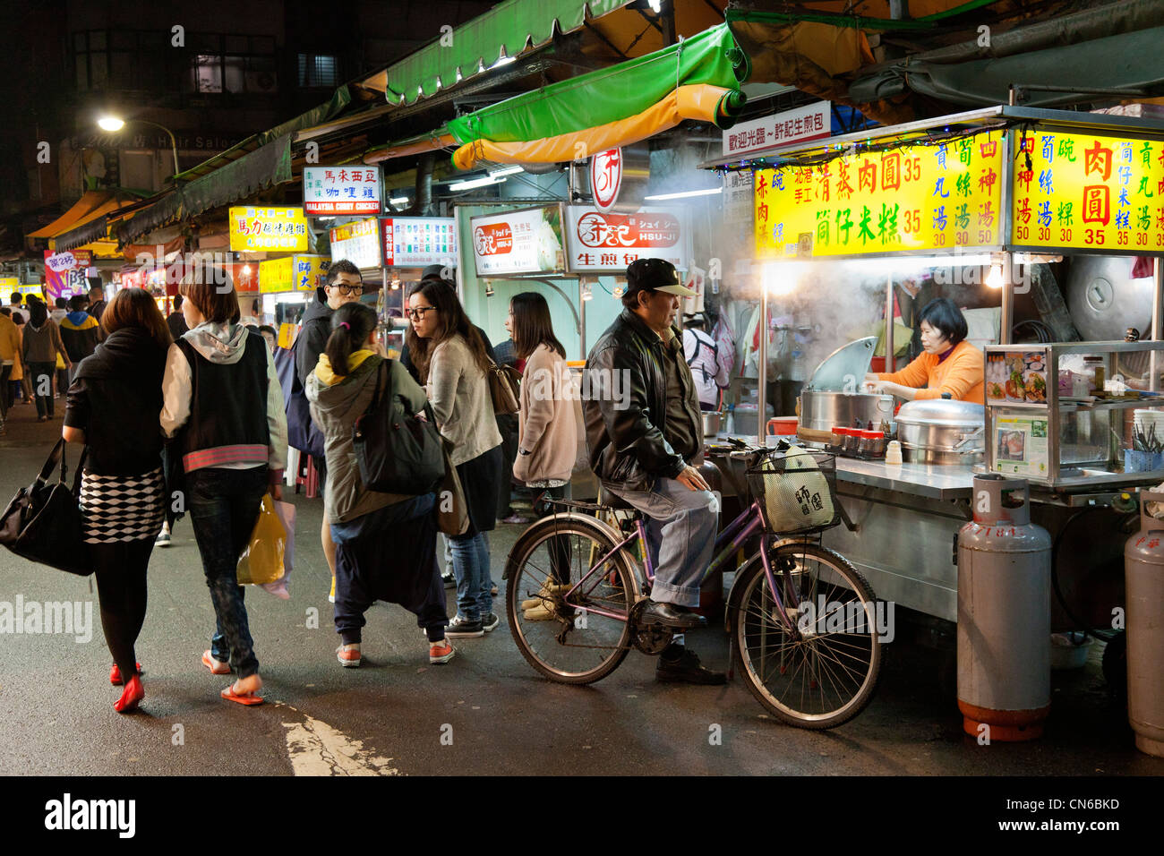 Man on cycle shopping for food in Shida Night Market, Taipei, Taiwan. JMH5636 Stock Photo