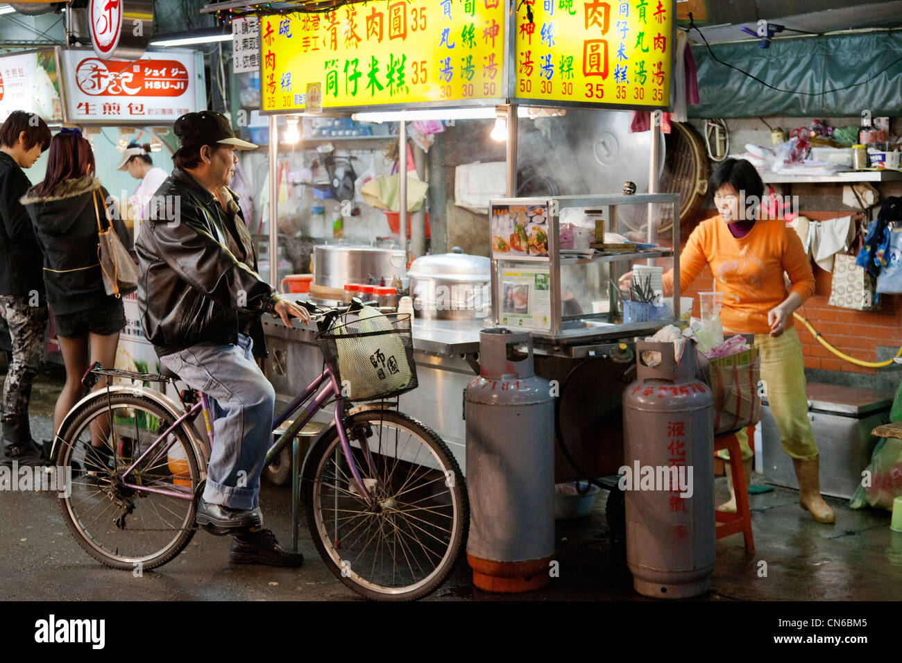 Man on cycle shopping for food in Shida Night Market, Taipei, Taiwan. JMH5637 Stock Photo