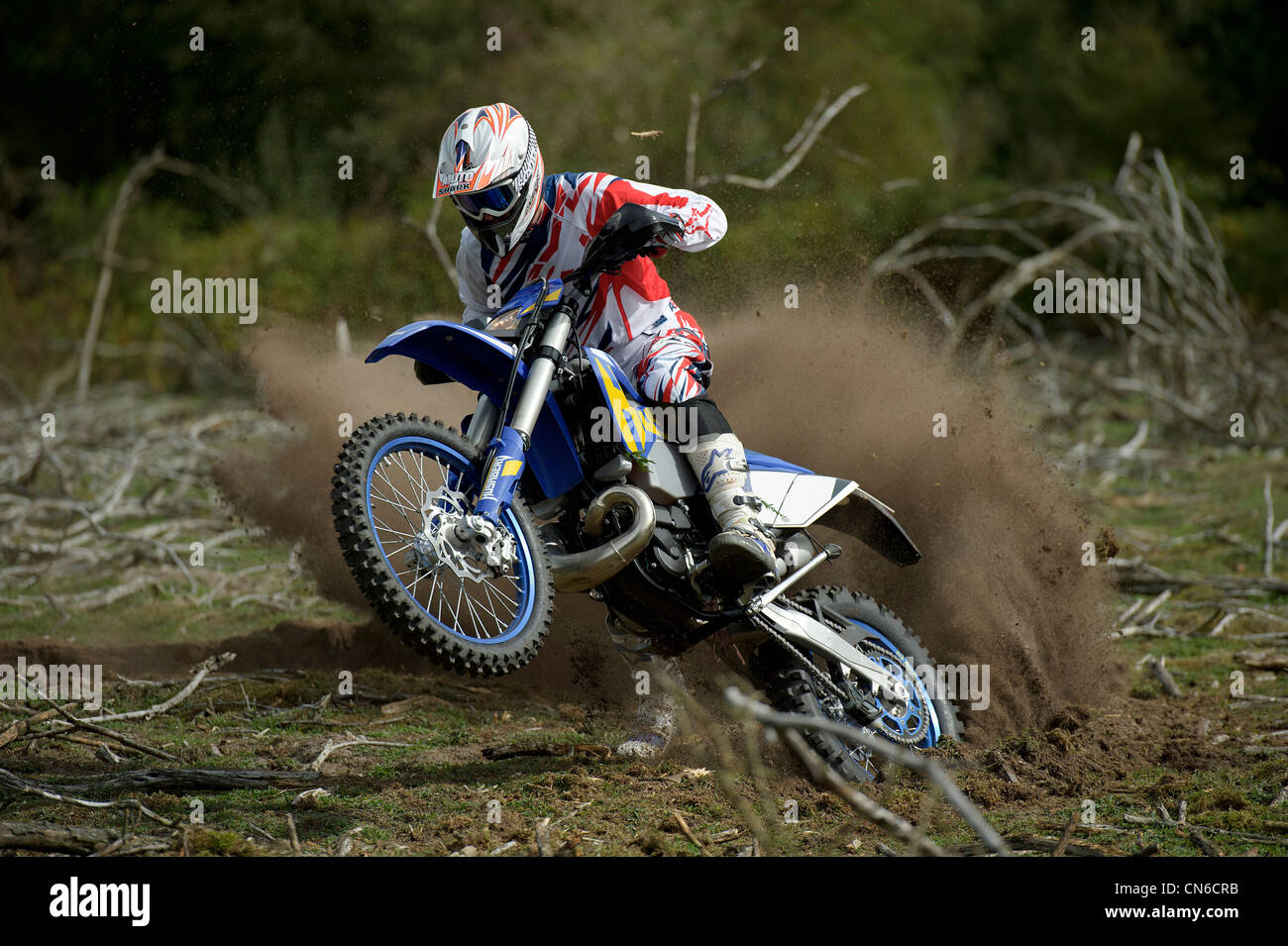 motocross racer rider riding around corner throwing up lots of roost ...