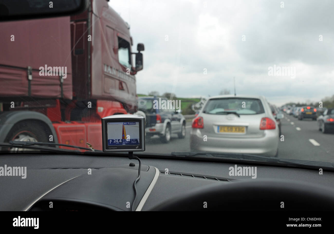 TomTom satellite Navigation unit on dashboard of a car stuck in stationary traffic on M6 Motorway UK Stock Photo