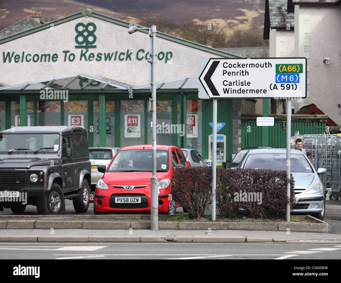 Keswick town centre with sign for other cumbrian towns. Stock Photo