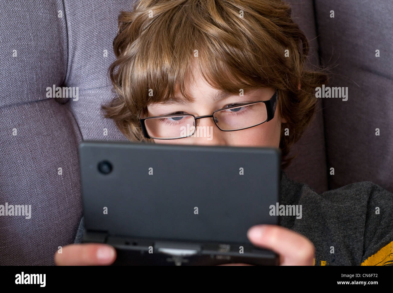 A boy playing on a hand-held Nintendo DSi games console Stock Photo