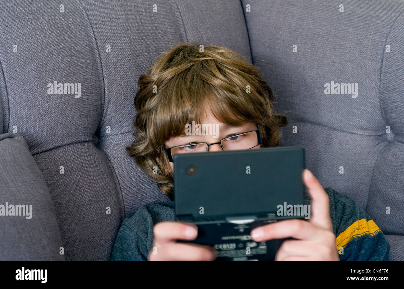 A boy playing on a hand-held Nintendo DSi games console Stock Photo
