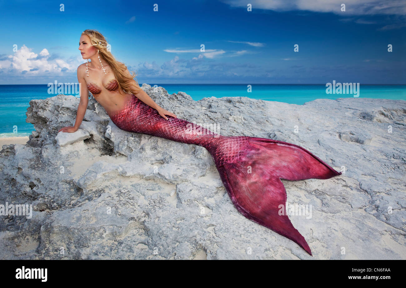 Mermaid sunning herself on the rocks in Cancun Mexico Stock Photo