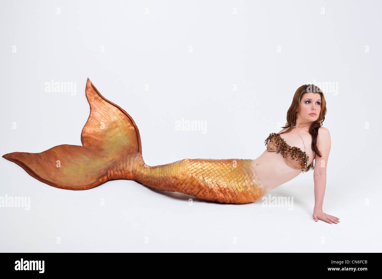 Mermaid posing in studio, with a decorative wire mesh top Stock Photo
