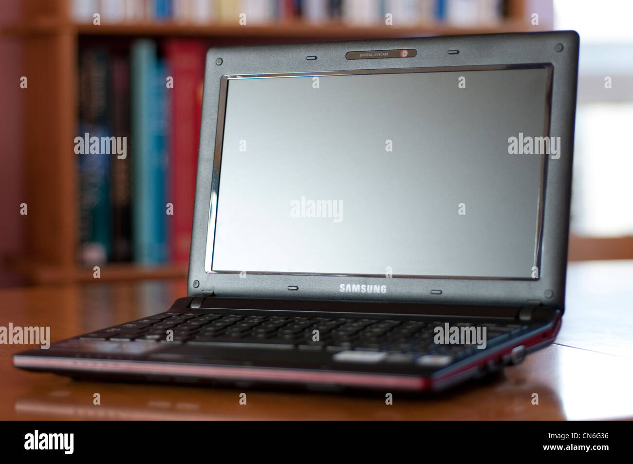 Laptop with a bookcase in the background Stock Photo