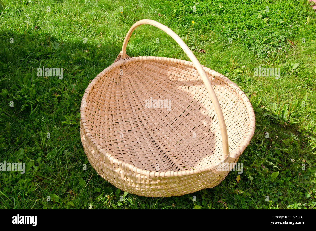 Wicker basket handmade on green grass. Village industrial object. Stock Photo