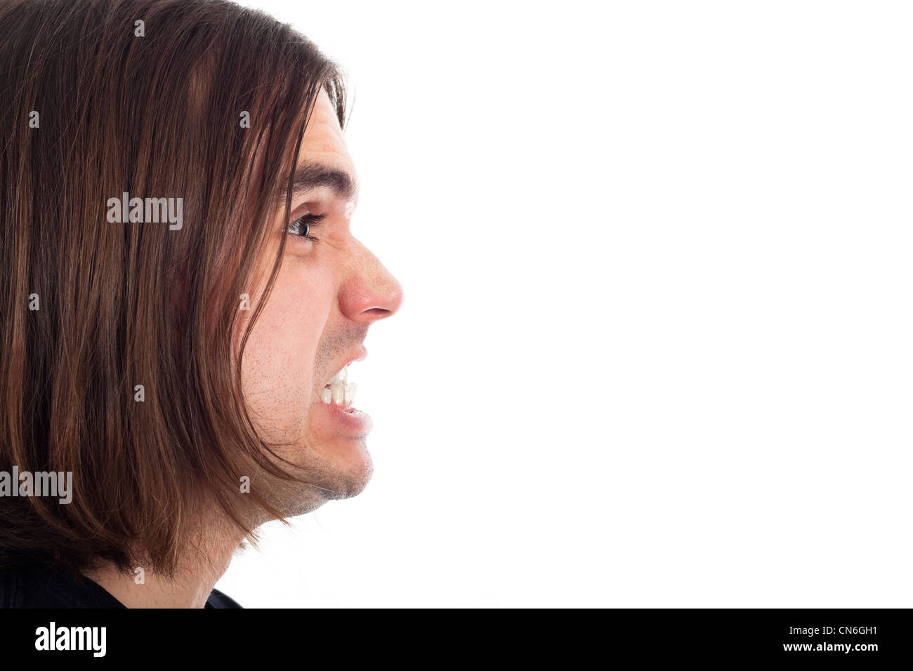 Profile of young long haired man face shouting, isolated on white background with large copy space. Stock Photo