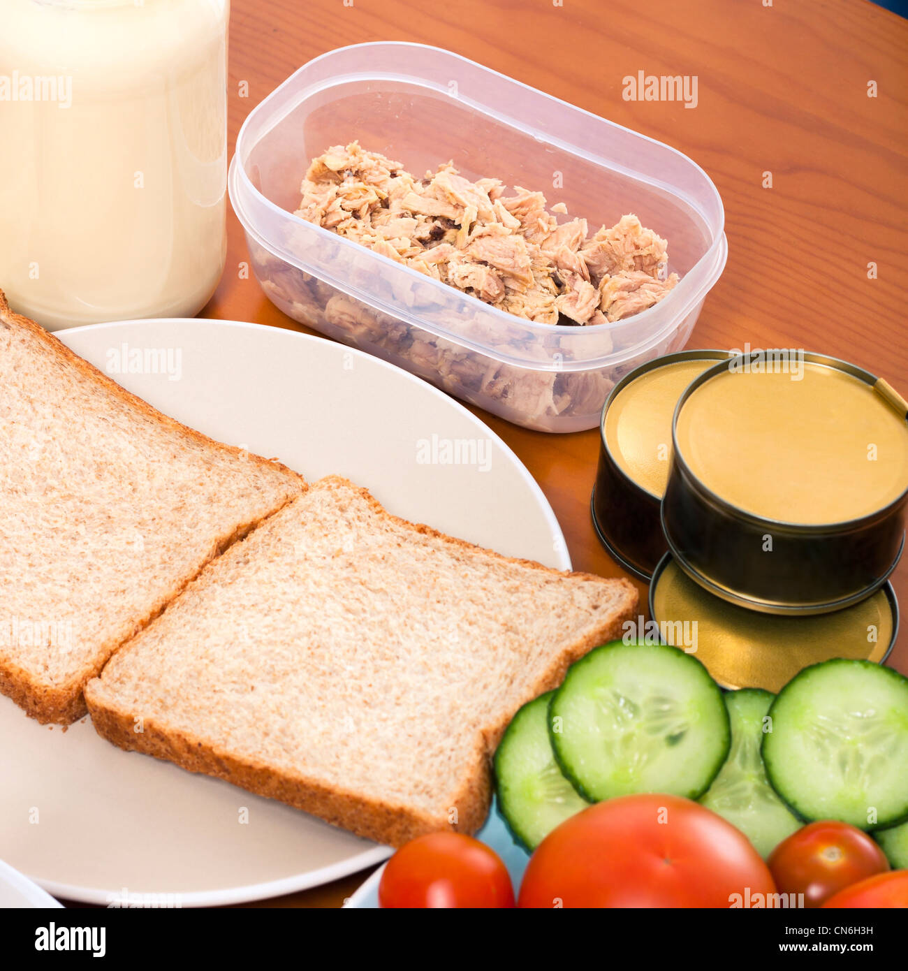 Detail of kitchen table with tuna meat, bread and vegetable. Stock Photo