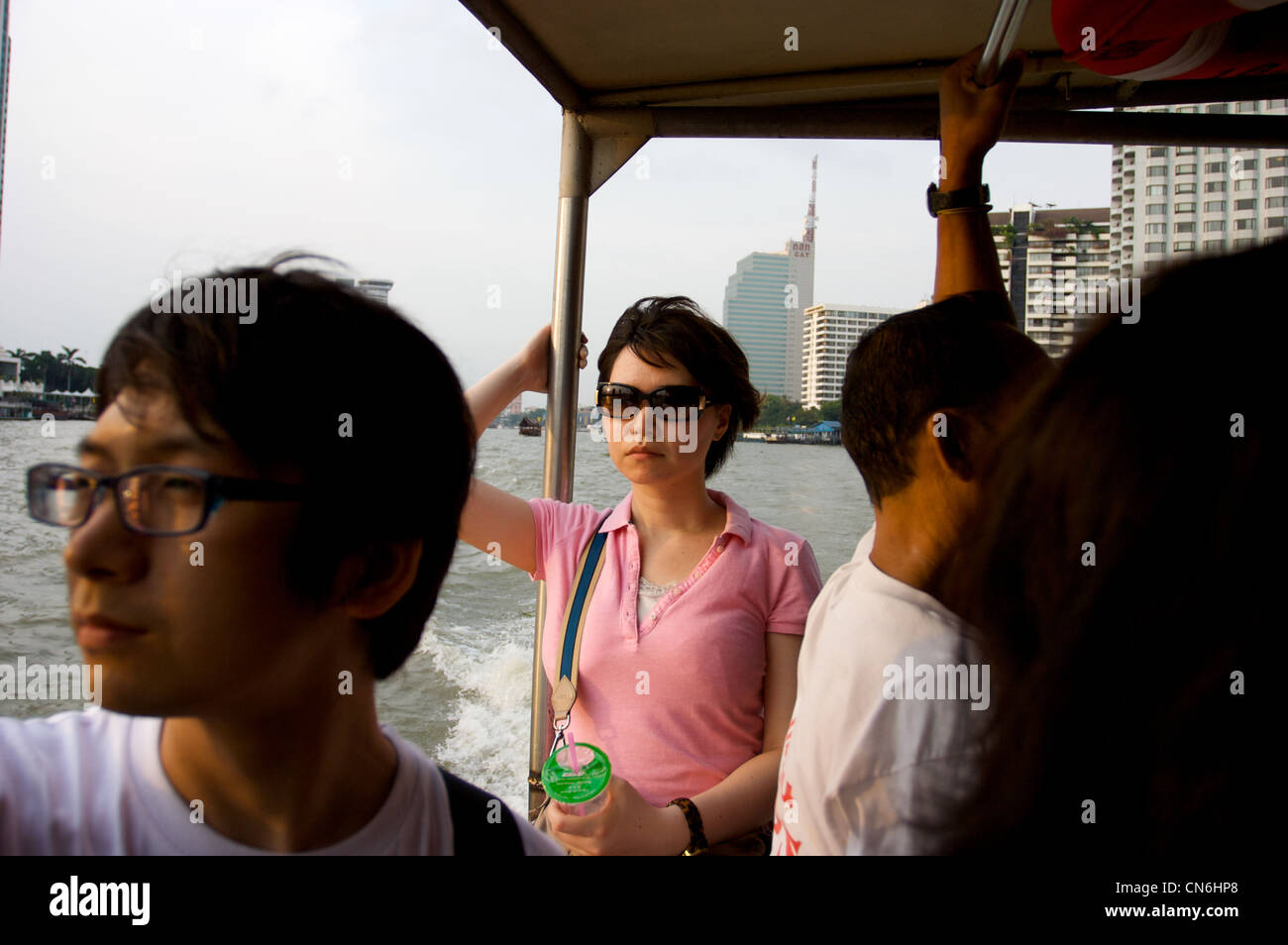 young lady enjoy river scene,passengers on ferry crossing at ta tein station, Bangkok,Thailand Stock Photo