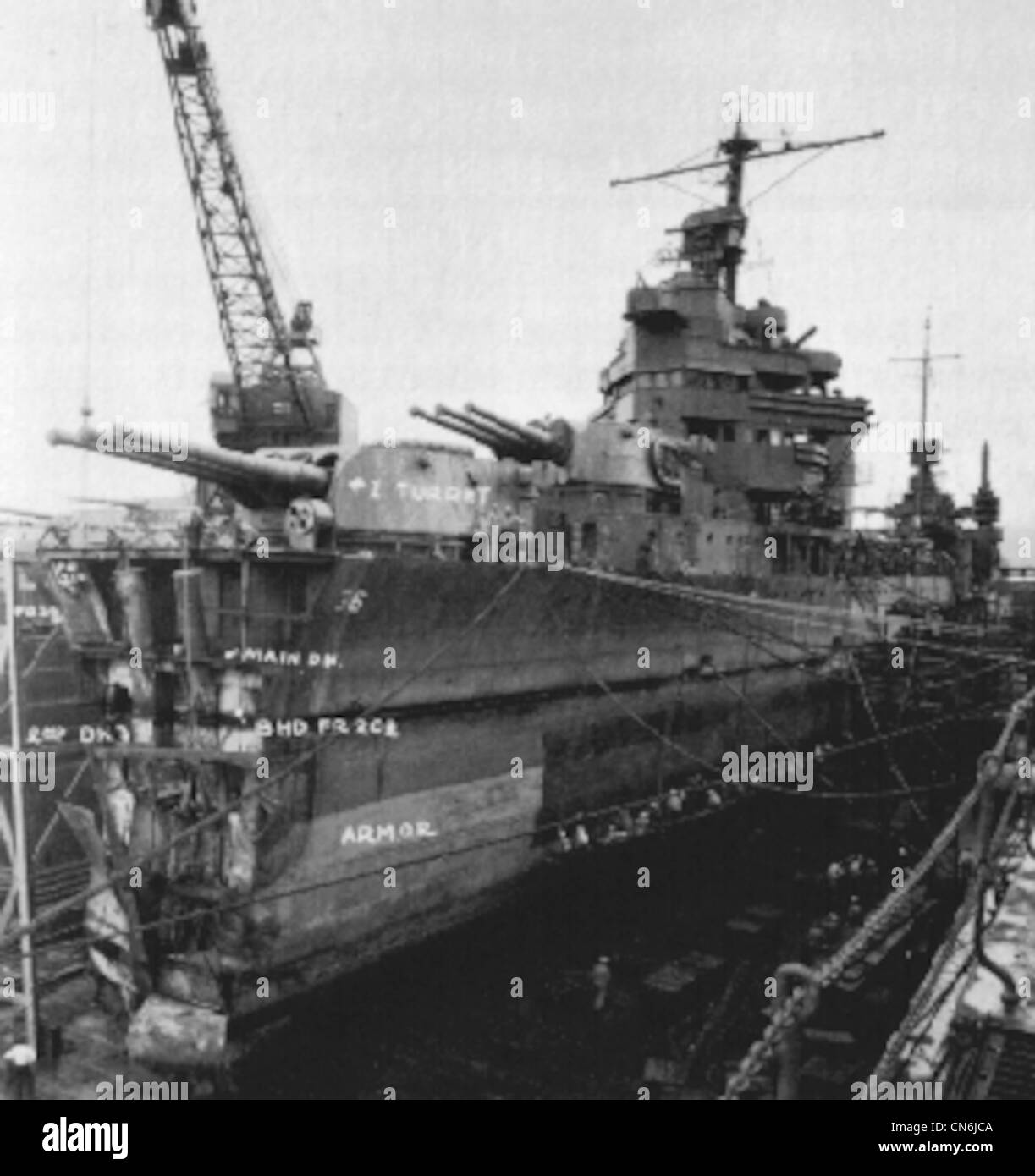 Minneapolis at Pearl Harbor in March, 1943 being repaired after torpedo damage at the Battle of Tassafaronga on November 30, 1942. Minneapolis was flagship of TF-67 and was hit by two torpedoes; one blew her bow off, ahead of #1 turret and the other struck further aft amidships. Stock Photo