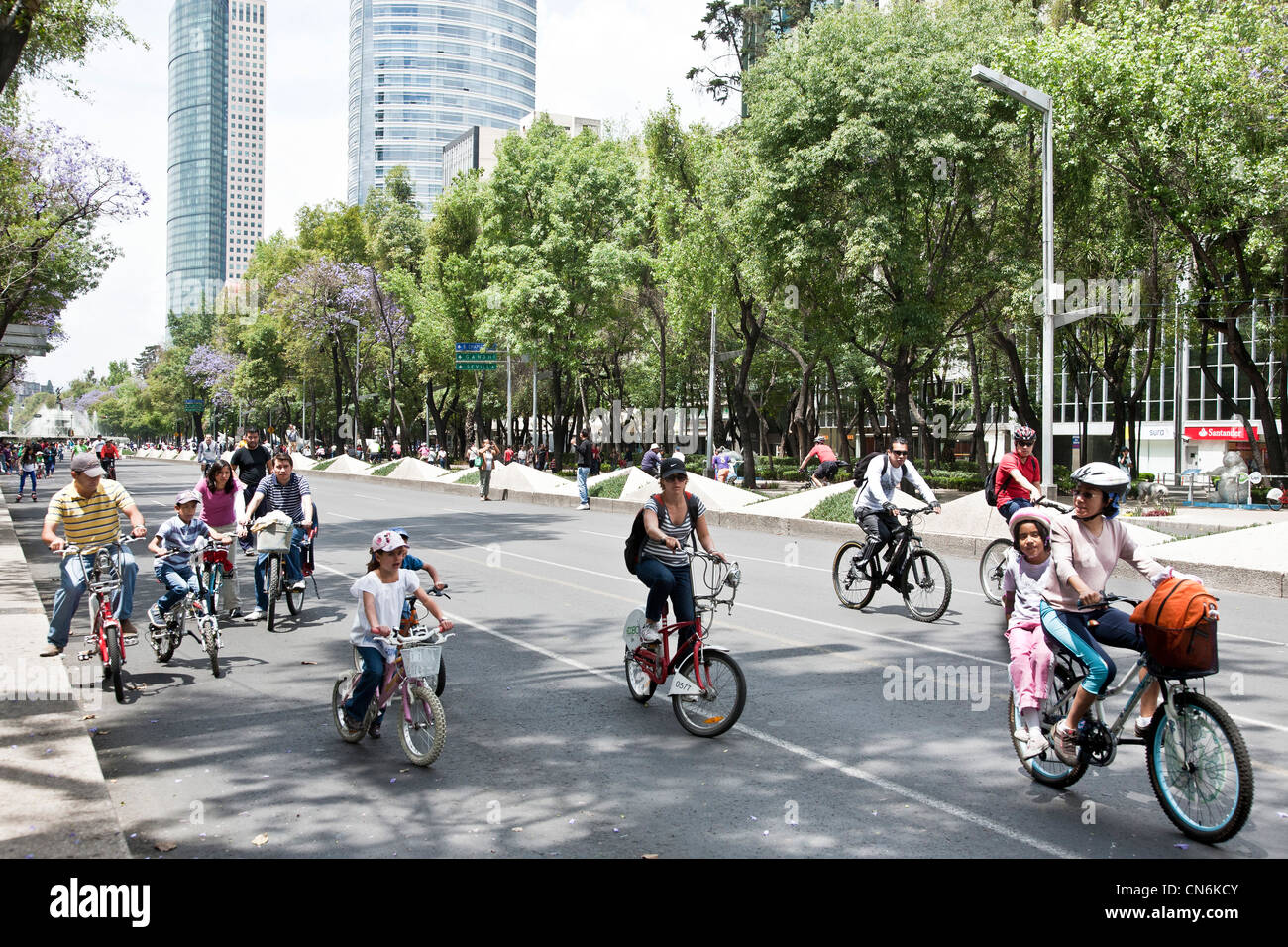 Mexican families on bicycles are among bicyclists & rollerbladers on Paseo de la Reforma on beautiful spring Sunday Mexico City Stock Photo