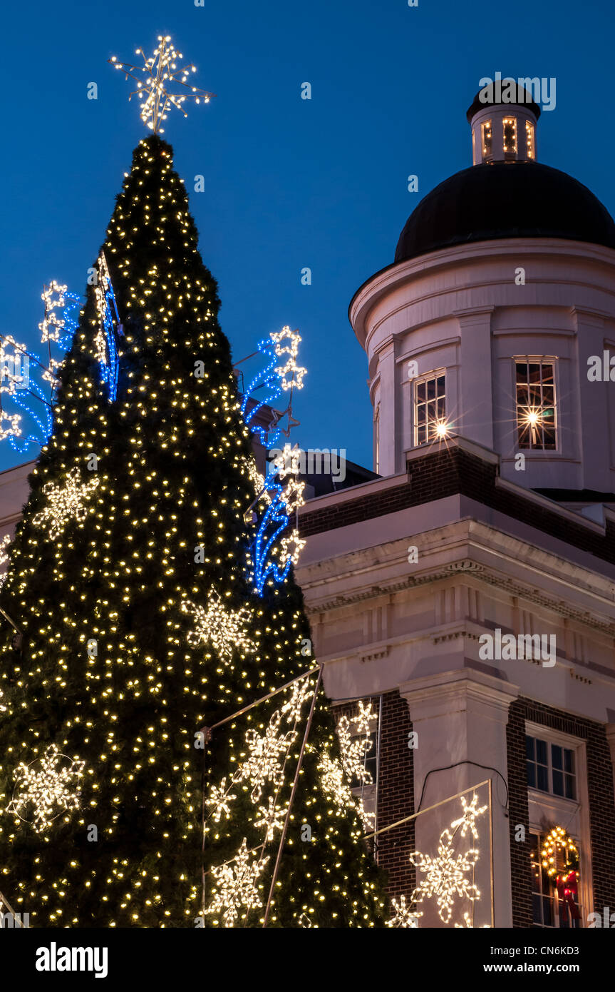 Christmas tree with lights and county courthouse in small town in United States against dusky blue sky Stock Photo