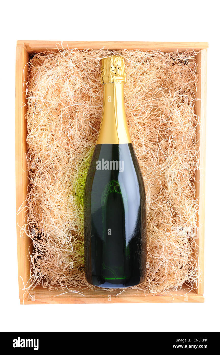 Overhead shot of a single champagne bottle in a wood shipping crate filled with packing straw. Stock Photo