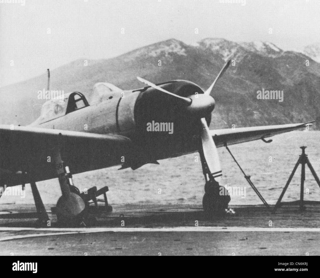 A Mitsubishi A6M Kansen AI-156 Zero fighter aboard the Imperial Japanese Navy aircraft carrier Akagi at Hitokappu Bay, Kuriles in November 1941 prior to departing for the attack on Pearl Harbor. Note the number 56 on the undercarriage fairing and lower engine cowling. The grid of black dots on the deck are, tie down points for securing the aircraft. Stock Photo