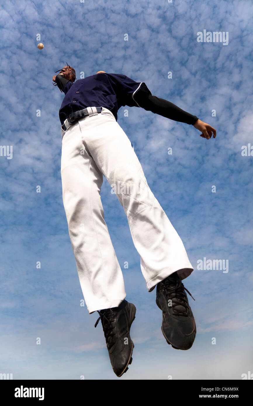baseball player jumping and catching the ball Stock Photo