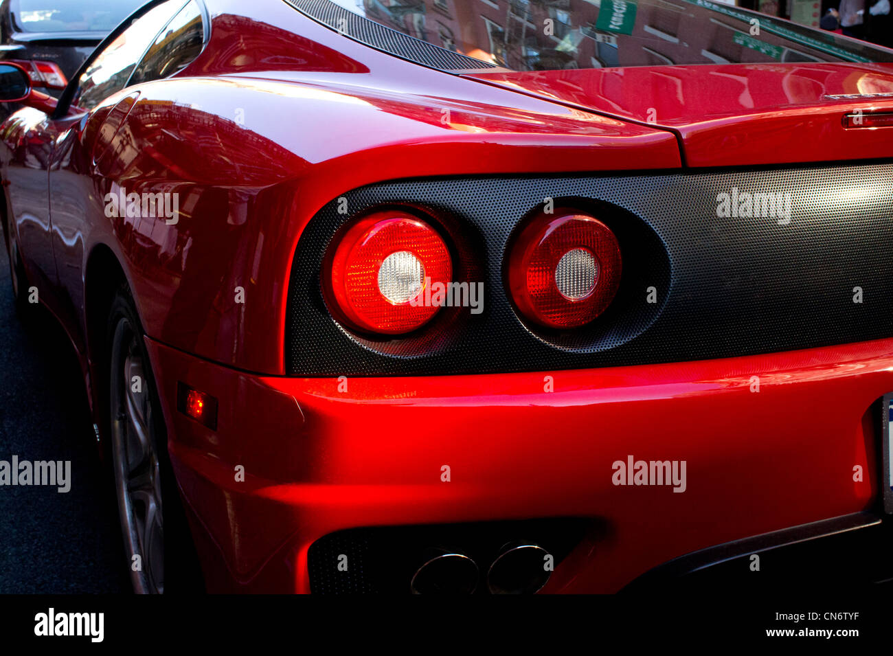 Red Ferrari moving slowly in New York City traffic. Stock Photo