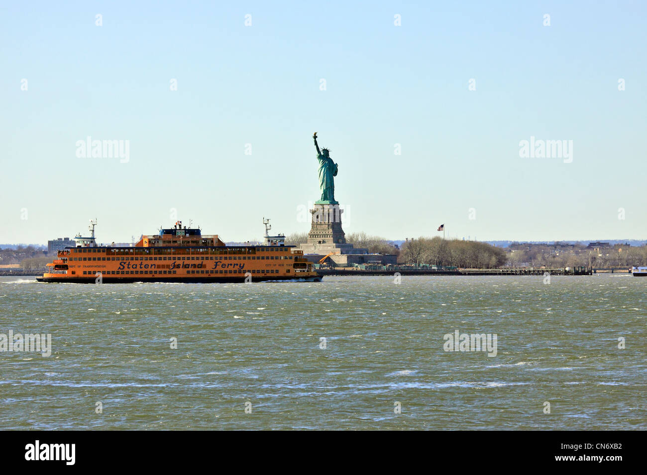 The Staten Island Ferry passes in front of the Statue of Liberty in New