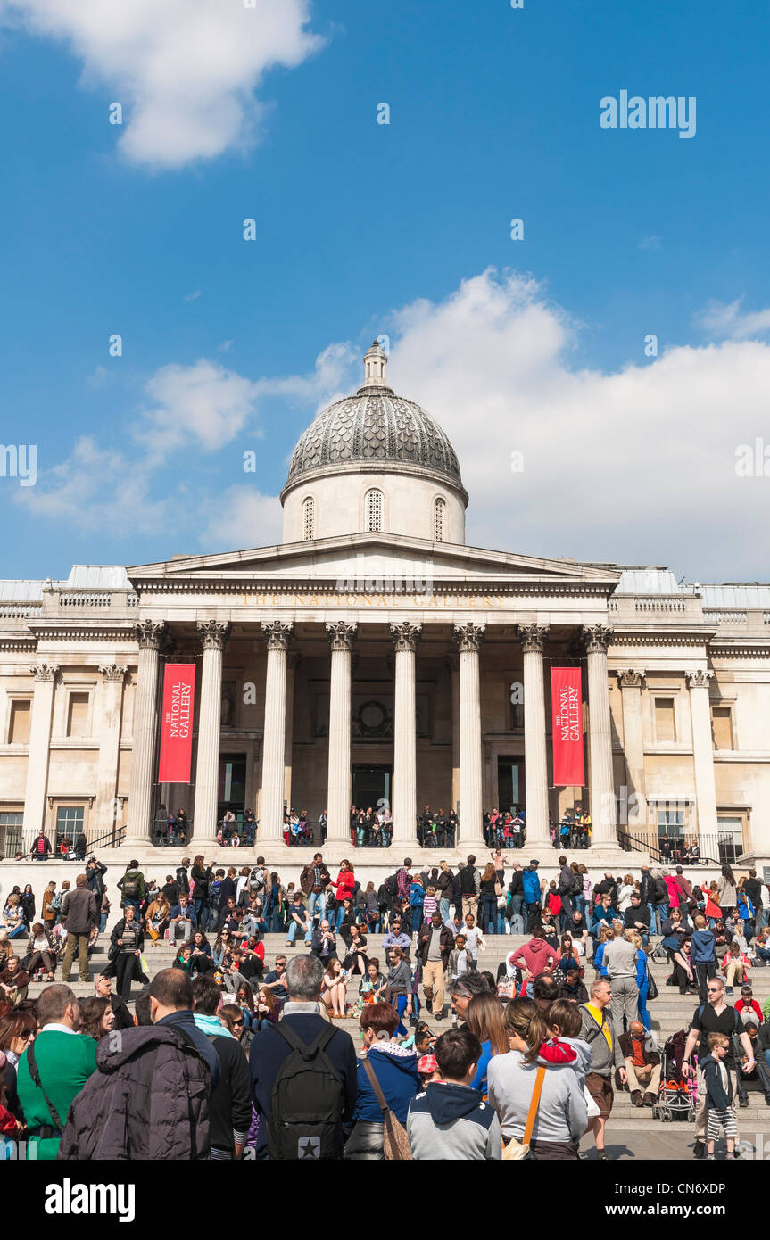 LONDON, UK - APRIL 02: Facade of The National Gallery in Trafalgar Square, with public enjoying the sun. Stock Photo
