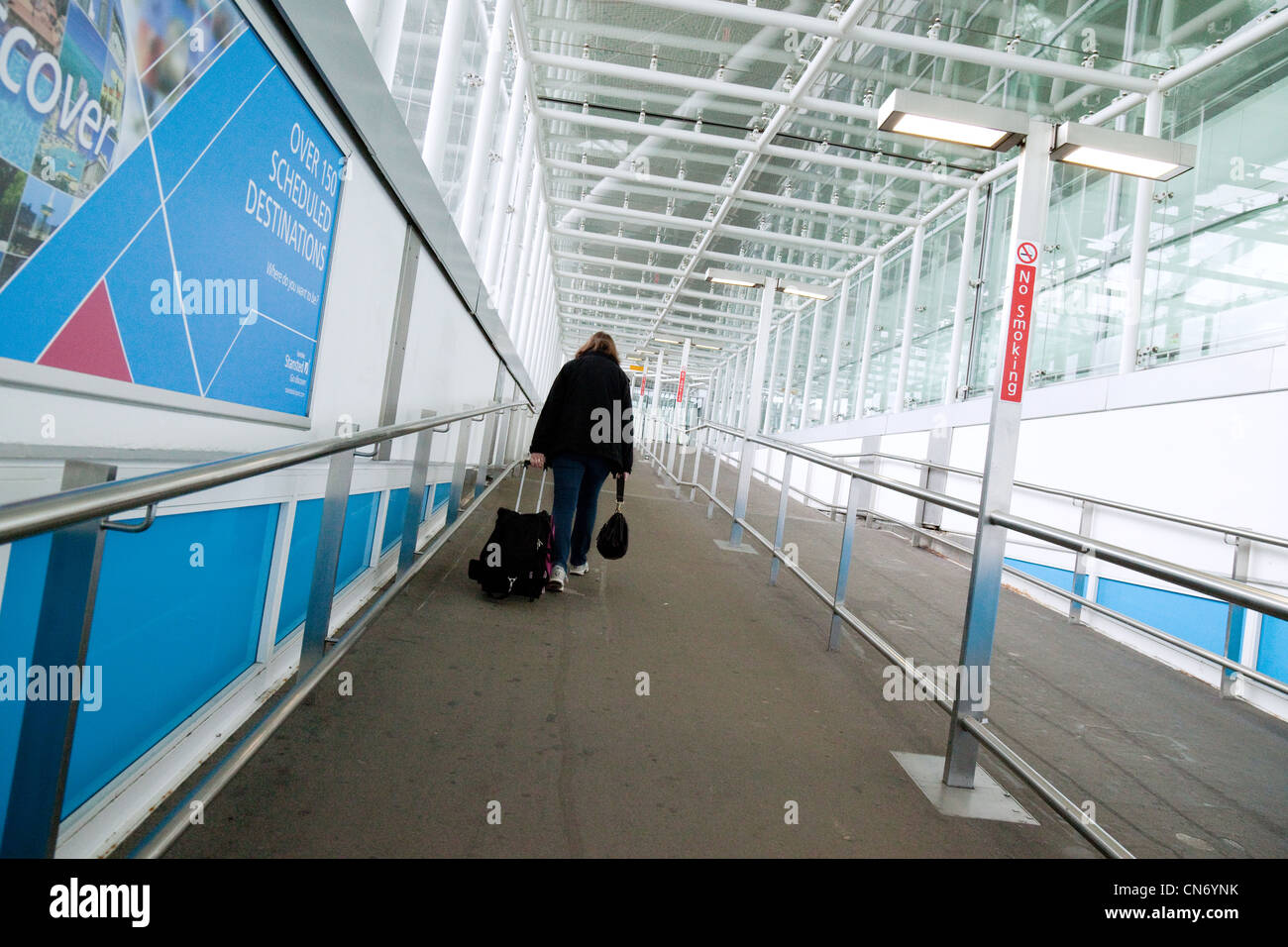 A lone woman passenger arriving at Stansted airport Essex UK Stock Photo