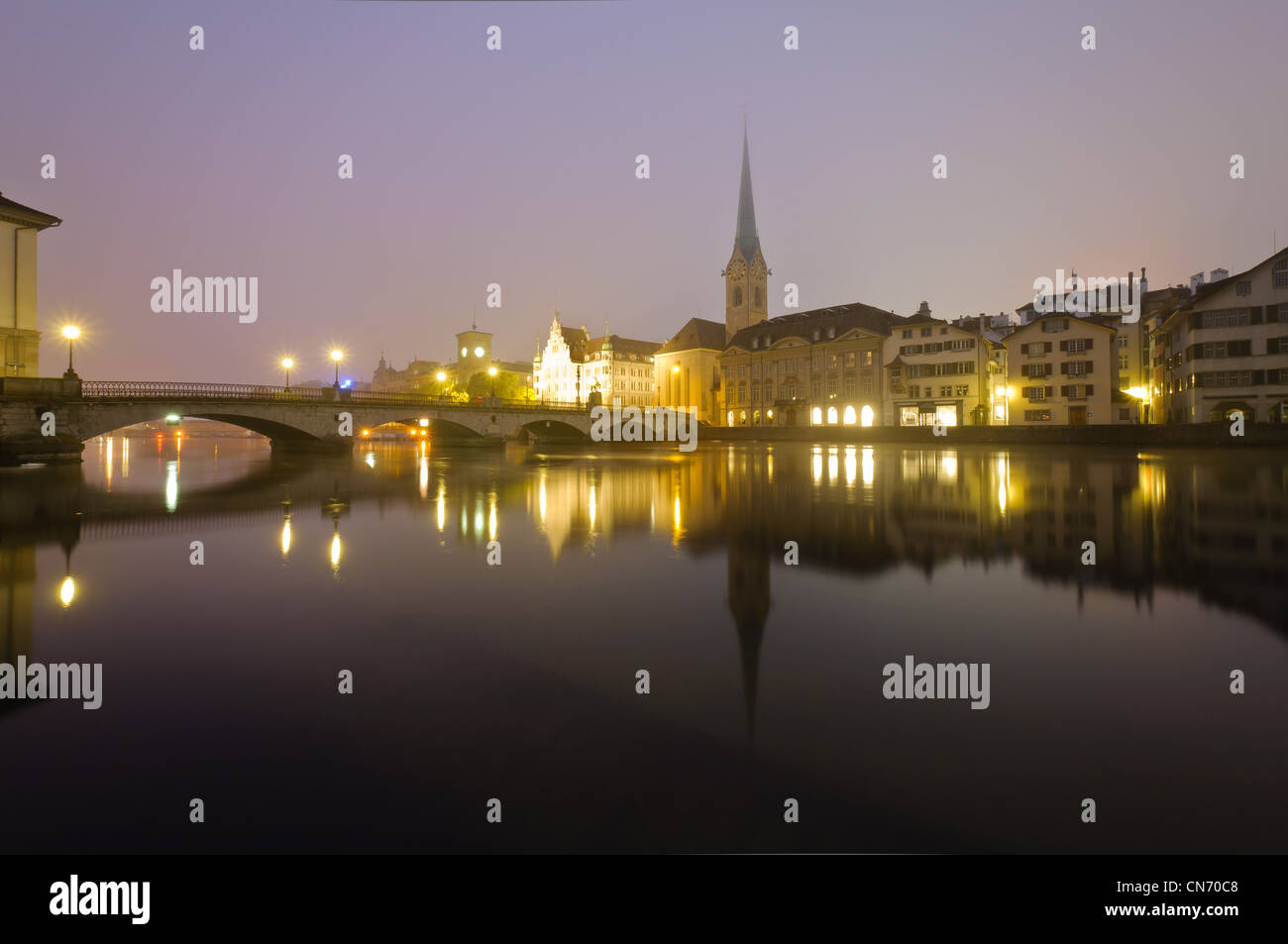 View of Zurich and old city center reflecting in the river Limmat at night. Stock Photo