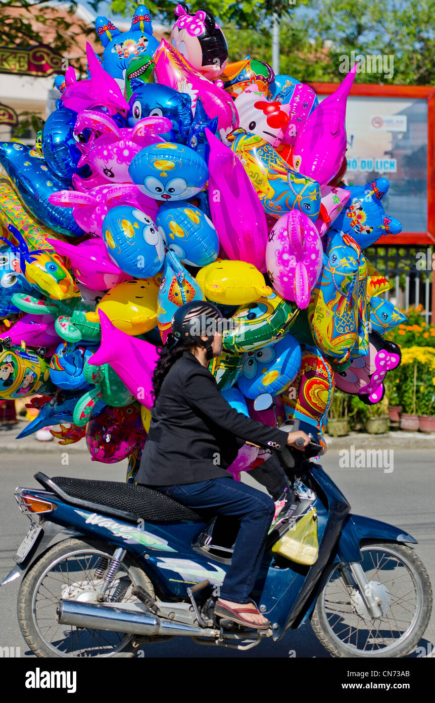 Vietnamese Woman Drives Past Helium Balloons for Sale During Tet, Hoi An, Vietnam Stock Photo