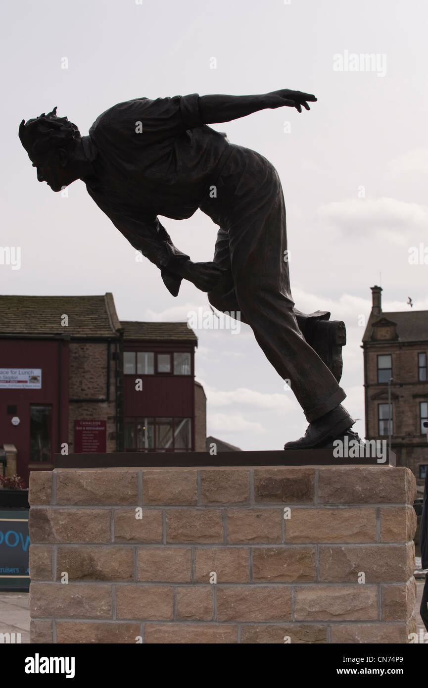 Close-up of bronze statue of cricketer Fred (Freddie) Trueman (fast bower in action, silhouetted & bowling) - Skipton, North Yorkshire, England, UK. Stock Photo