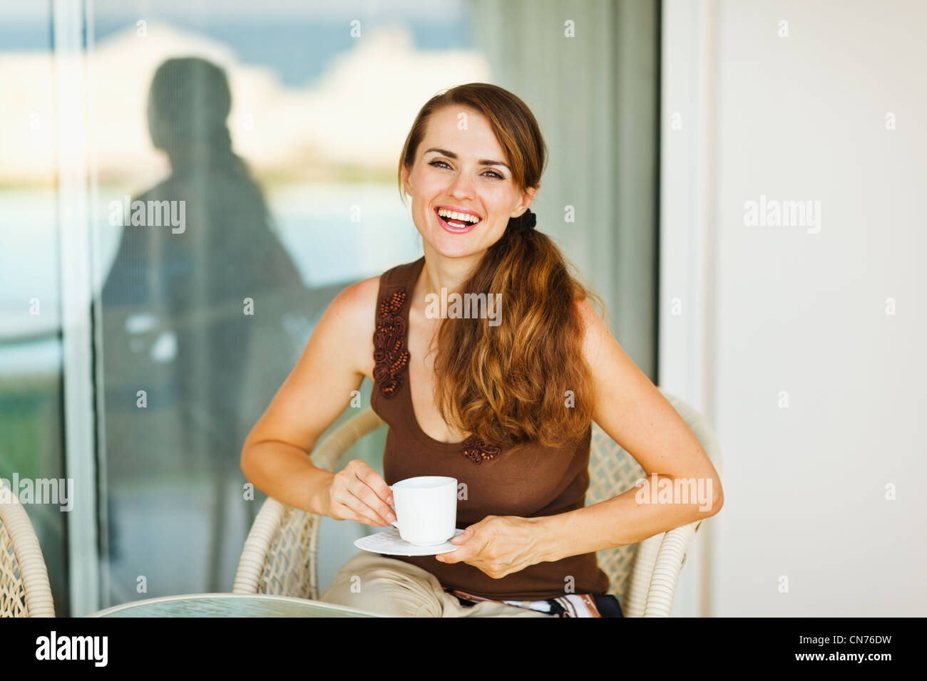 Happy woman enjoying coffee on terrace Stock Photo
