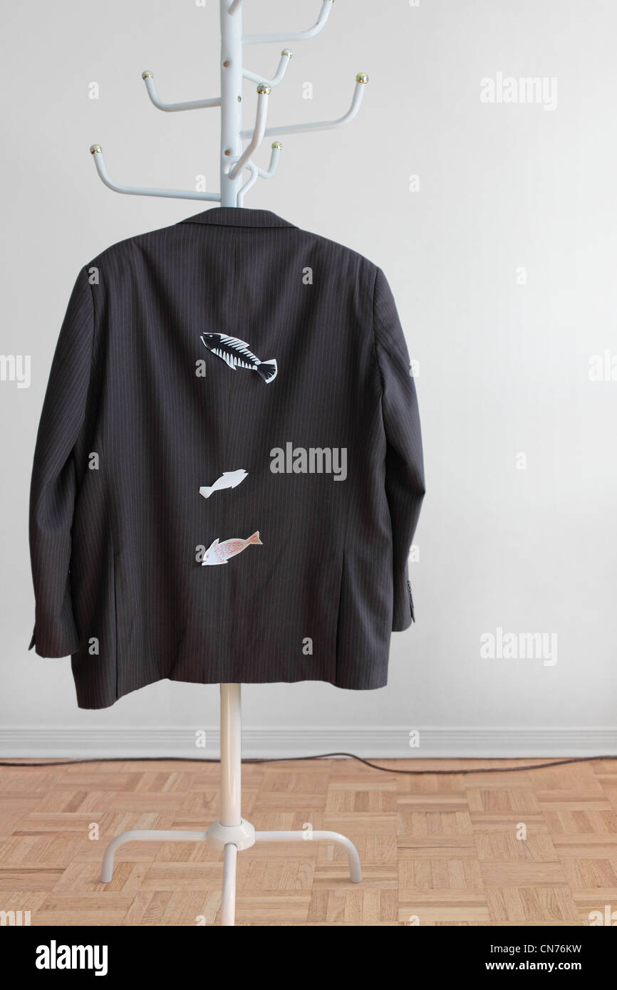 We see the back of a man's suit jacket hanging on a coat rack with