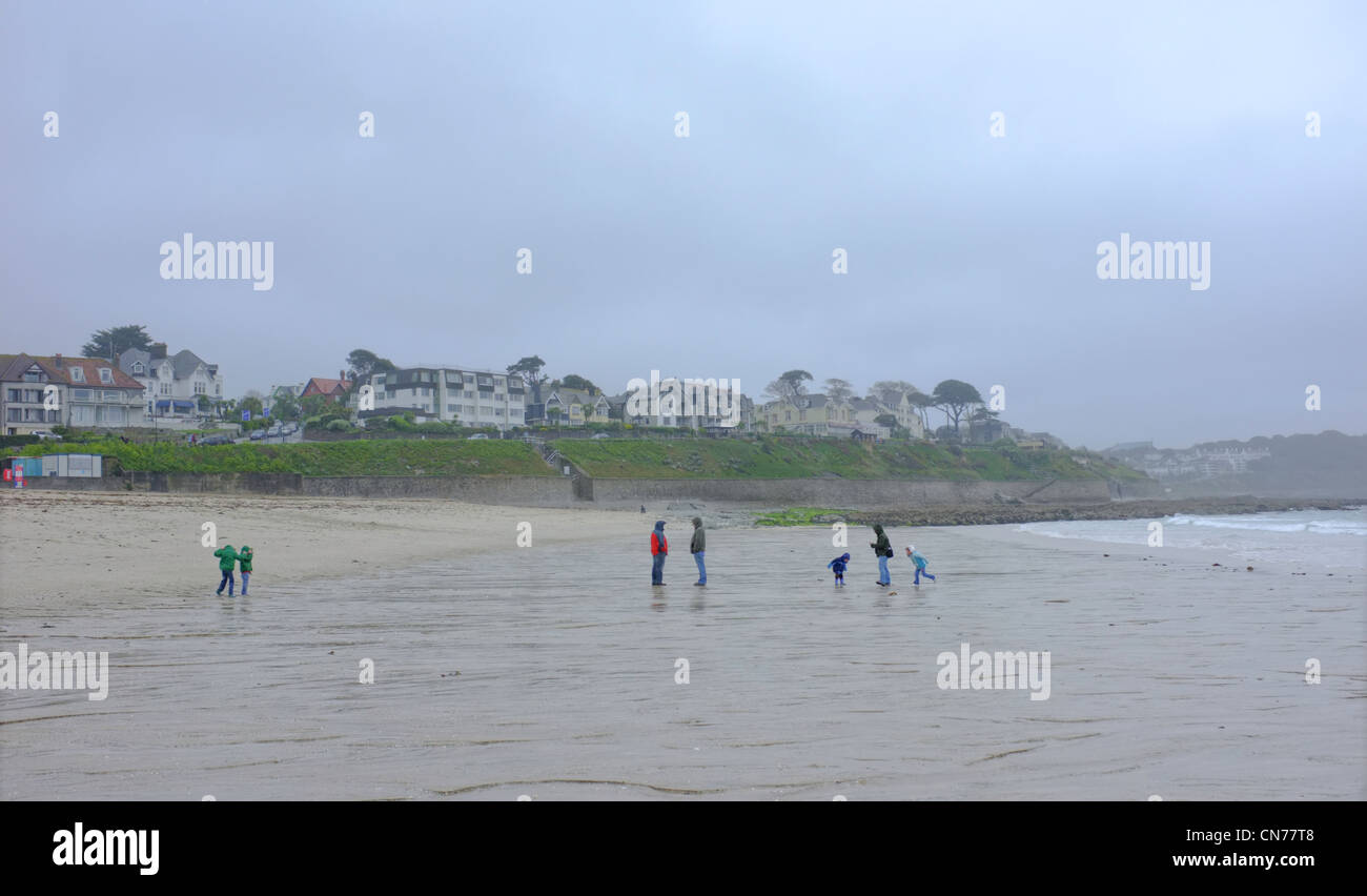 A family on  Gyllyngvase beach  in Cornwall on a wet and windy day Stock Photo