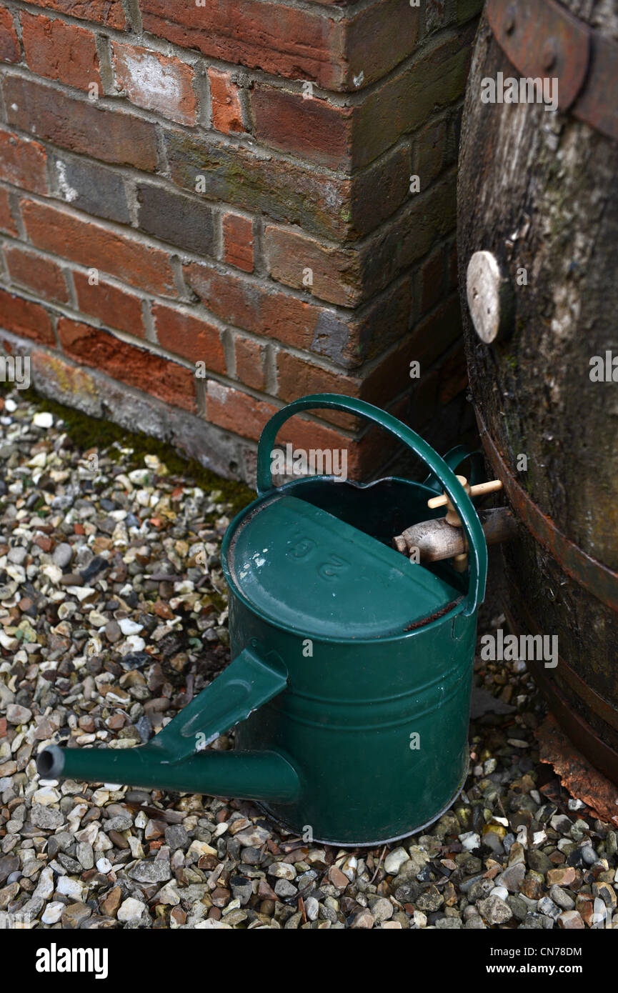 A watering can and water butt to save rainwater for a garden in the
